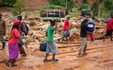 Cyclone survivors leave the Ngangu township with their belongings to Chimanimani Hotel where hundreds are sheltered on 18 March 2019 in Ngangu township Chimanimani, Manicaland Province, eastern Zimbabwe, after the area was hit by the cyclone Idai. Picture: AFP