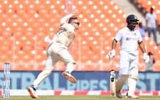 England's Dom Bess (L) bowls as India's Rishabh Pant watches on the second day of the fourth Test cricket match between India and England at the Narendra Modi Stadium in Motera on 5 March 2021. Picture: Sajjad Hussain/AFP