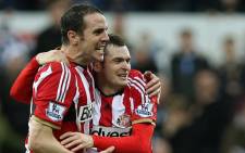 Sunderland's Irish defender John O'Shea (L) celebrates at the final whistle with goal-scorer, Sunderland's English midfielder Adam Johnson after the English Premier League football match between Newcastle United and Sunderland at St James' Park in Newcastle-upon-Tyne, north east England, on 21 December, 2014. Picture: AFP