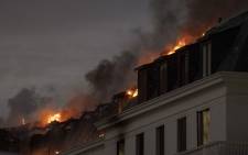 FILE: Flames arise from the National Assembly, the main chamber of the South African Parliament buildings, after a fire that broke out the day before restarted, in Cape Town, on 3 January 2022. Picture: RODGER BOSCH/AFP