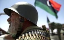 A Libyan rebel fighter wearing an ammunition belt waits in a staging area Ajdabiya on April 14, 2011. Picture: AFP