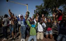 University of Johannesburg students raise their hands in front of a riot police line while blocking a motorway during clashes on September 28, 2016 outside the University of Johannesburg Campus. Picture: AFP