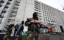 FILE:A pro-Russian militant guards a regional state building that was seized by separatists in eastern Ukrainian city of Donetsk on 2 June, 2014. Picture:AFP.