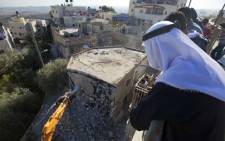 FILE: Palestinian Rafet Dabash looks at a bulldozer destroying his own home in the east Jerusalem district of Sur Baher on November 30, 2012 after an Israeli court ruled that the house was built without a municipality permit. Picture: AFP.