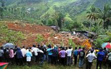 The landslide area being excavated by a bulldozer as people watch during rescue operations at Meeriyabedda, Haldummulla in Badulla 218 kms towards the interior from Colombo, Sri Lanka, 29 October 2014. Picture: EPA/M.A.PUSHPA KUMARA.