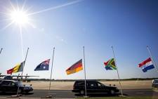 A convoy of hearses carrying coffins containing the remains of victims of the downed Malaysia Airlines flight MH17 drive past flags flying at half-mast in the Netherlands, 23 July 2014. Picture: AFP.