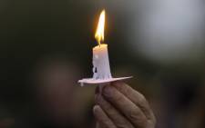 A man holds a candle in Burbank, California on 24 October 2021 during a candlelight vigil for cinematographer Halyna Hutchins, who was accidentally killed by a prop gun fired by actor Alec Baldwin. Picture: AFP