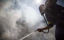 FILE: A firefighter puts out a veld fire in Cape Town. Picture: Thomas Holder/EWN.