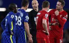 Referee Anthony Taylor (C) reacts as he talks to Chelsea defender Cesar Azpilicueta (2L) and Liverpool midfielder Jordan Henderson (R) as he reviews a challenge between Chelsea Mason Mount and Liverpool defender Kostas Tsimikas (both unseen) during the English Premier League football match between Chelsea and Liverpool at Stamford Bridge in London on 2 January 2022. Picture: Adrian Dennis/AFP