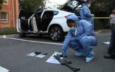 FILE: A forensic detective inspects a firearm taken from a murder conspiracy suspect's vehicle at a Road Lodge in Rivonia on 9 January 2014. Picture: Vumani Mkhize/EWN.