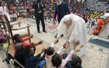 Pope Francis greets children at the Akamasoa Association. Picture: @VaticanNews/Twitter