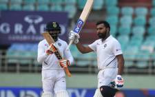 Indian cricketer Rohit Sharma (R) raises his bat after scoring a century (100 runs) during the fourth day's play of the first Test match between India and South Africa at the Dr. Y.S. Rajasekhara Reddy ACA-VDCA Cricket Stadium in Visakhapatnam on 5 October 2019. Picture: AFP