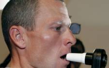 Lance Armstrong (US Postal/USA) blows in a tester during the traditional medical check-up on July 4, 2001 in Liege, Belgium, two days before the official start of the 91st Tour de France cycling race. Picture: AFP.