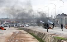 Policemen shoot canister of tear gas to disperse people during a demonstration and attacks against South African-owned shops in Abuja, on 4 September 2019. Picture: AFP