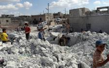 Syrians check a damaged house, reportedly hit by US-led coalition air strikes, in the village of Kfar Derian in the western Aleppo province on 23 September, 2014. Picture: AFP.