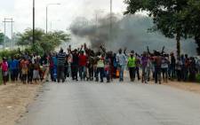 Angry protesters gesture as they block the main route to Zimbabwe's capital Harare from Epworth township on 14 January 2019 after announced a more than hundred percent hike in fuel prices. Picture: AFP