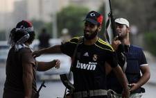 Rebel fighters celebrate on August 25, 2011 after taking control of the southern Tripoli district of Abu Salim. Picture: AFP