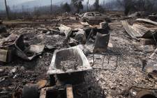 The shells of burnt out cars and appliances are all that's left of the homes of South African National Parks workers. Picture: Bertram Malgas/EWN