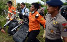 Members of an Indonesian search and rescue team carry passenger seats from the AirAsia flight 8501 in Pangkalan Bun on 5 January, 2015. Picture: AFP.