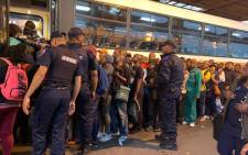 Law enforcement officers help keep order as commuters board a bus following a protest near the Cape Town bus terminal after taxi operators were arrested for outstanding warrants on 15 October 2019. Picture: Kaylynn Palm/EWN