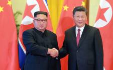 This picture taken on 19 June 2018 and released by North Korea's official Korean Central News Agency (KCNA) via KNS on June 20, 2018 shows North Korean leader Kim Jong Un (L) shaking hands with Chinese President Xi Jinping at the Great Hall of the People in Beijing. Picture: AFP

