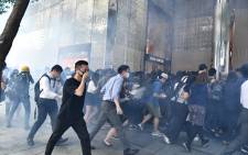 People react after tear gas was fired by police during a protest in Hong Kong on 11 November 2019. Picture: AFP