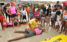 FILE: Children watch a demonstration by rescue services at a Cape Town beach. Picture: Supplied. 
