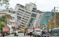 Rescue and emergency workers block off a street where a building came off its foundation, the morning after a 6.4 magnitude quake hit the eastern Taiwanese city of Hualien, on 7 February 2018. Picture: AFP