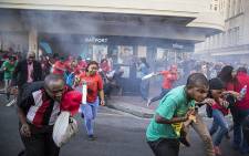 Protesters flee for cover as police fire stun grenades in the Cape Town CBD. Picture: Thomas Holder/EWN. 
