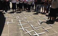 Families and supporters of 37 psychiatric patients who died after being transferred from Life Healthcare Esidimeni gather around white handmade crosses during a march at the Gauteng Health MEC’s offices on 27 October 2016. Picture: Masego Rahlaga/EWN.