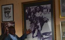 Photographer Sam Nzima with an image of the iconic Hector Pieterson picture he took in 1976. Picture: EWN