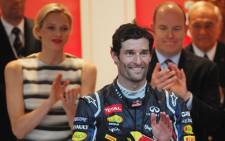 Red Bull Racing's Australian driver Mark Webber (C) celebrates on the podium as Prince Albert of Monaco and Princess Charlene (L) stand at the Circuit de Monaco on May 27, 2012. Picture: AFP