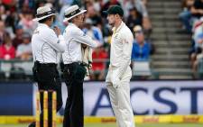 FILE: Australian fielder Cameron Bancroft is questioned by Umpires Richard Illingworth and Nigel Llong during the third day of the third Test cricket match between South Africa and Australia at Newlands cricket ground on 24 March 2018 in Cape Town. Picture: AFP