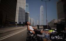 A pro-democracy protester sleeps on an empty road in the Admiralty district of Hong Kong early on 7 October, 2014. Picture: AFP.