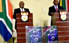 Chief Justice Raymond Zondo and President Cyril Ramaphosa stand as a backdrop to hard copies of the final parts of the State Capture report on Wednesday, 22 June 2022. Picture: GCIS