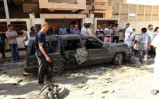 Bystanders gather at the scene of car bomb explosion outside the Swedish consulate in the eastern Libyan city of Benghazi on October 11, 2013. Picture: AFP