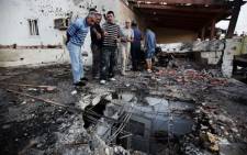 Israeli men inspect the damage caused to a house by a rocket launched by Palestinian militants from the Gaza Strip. Picture: AFP.