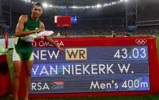 South Africa's 400m Olympic gold medallist Wayde van Niekerk points to his new world record displayed on a board after the Men's 400m Final at the Rio 2016 Olympic Games at the Olympic Stadium in Rio de Janeiro on August 14, 2016. Picture: AFP