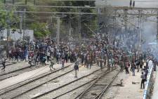 FILE: Hundreds of protesters stood on rail tracks in the southern city of Secunderabad, burning piles of debris to block passenger services and setting alight carriages on at least four trains. Picture: NOAH SEELAM / AFP