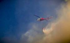 FILE: A helicopter drops water on a fire. Picture: Thomas Holder/EWN