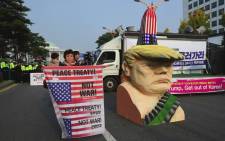An anti-Trump protestors hold signs next to an effigy of US President Donald Trump during a rally near the National Assembly in Seoul on 8 November, 2017 as Trump is due to address the South Korea's national assembly. Picture: AFP.