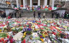 Floral tributes and candles are displayed outside the Stock Exchange in Brussels on March 27, 2016 as they lie in tribute to the victims of the coordinated terror attacks in the city claimed by the Islamic state group (IS) on March 22, in which 31 people were killed and over 300 injured. Picture: AFP.