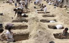 Yemenis dig graves for children who were killed when their bus was hit during a Saudi-led coalition air strike, that targeted the Dahyan market the previous day in the Houthi rebels' stronghold province of Saada on 10 August 2018. Picture: AFP.