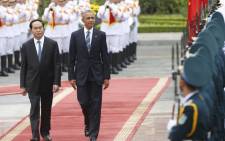 US President Barack Obama (C) walks with his Vietnamese counterpart Tran Dai Quang (L) as they review a guard of honour during a welcoming ceremony at the Presidential Palace in Hanoi on 23 May, 2016. Picture: AFP.