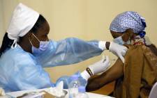 FILE: A medical worker injects a second dose of AstraZeneca vaccine to a patient in a COVID-19 vaccination centre in Kigali, Rwanda, on 27 May 2021. Picture: Ludovic MARIN/AFP