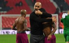 FILE: Manchester City manager Pep Guardiola embraces midfielder Raheem Sterling on the pitch after the English Premier League football match between Tottenham Hotspur and Manchester City at Wembley Stadium in London, on 14 April 2018. Picture: AFP