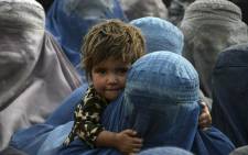 Women wait to receive a food donation from the Afterlife foundation during Islam's Holy fasting month of Ramadan in Kandahar on 27 April 2022.
