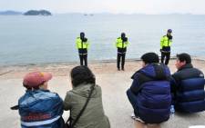 Policemen stand guard as South Korean relatives wait for missing passengers of a capsized ferry at a harbor in Jindo on 19 April. Picture: AFP.