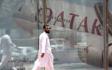 FILE: This photo taken on 5 June 2017 shows a man walking past the Qatar Airways branch in the Saudi capital Riyadh, after it had suspended all flights to Saudi Arabia following a severing of relations between major gulf states and gas-rich Qatar. Picture: AFP