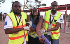 FILE: Paramedics help a student who was injured during an attack by al-Shabaab gunmen on the Garissa University College campus in Kenya on 2 April 2015. Picture: AFP.